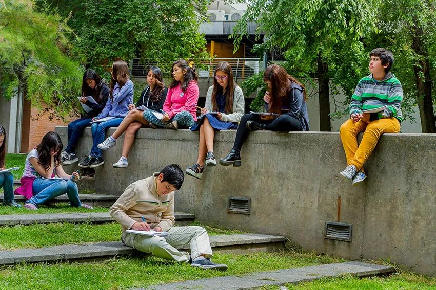 Imagen que muestra grupo de adolescentes haciendo una tarea al aire libre, en el Campus San Joaquín de la UC. Derechos de imagen pertenecen a Penta UC.